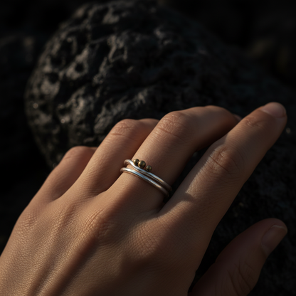 Close-up of Trinity Moon double band ring worn against dark volcanic stone