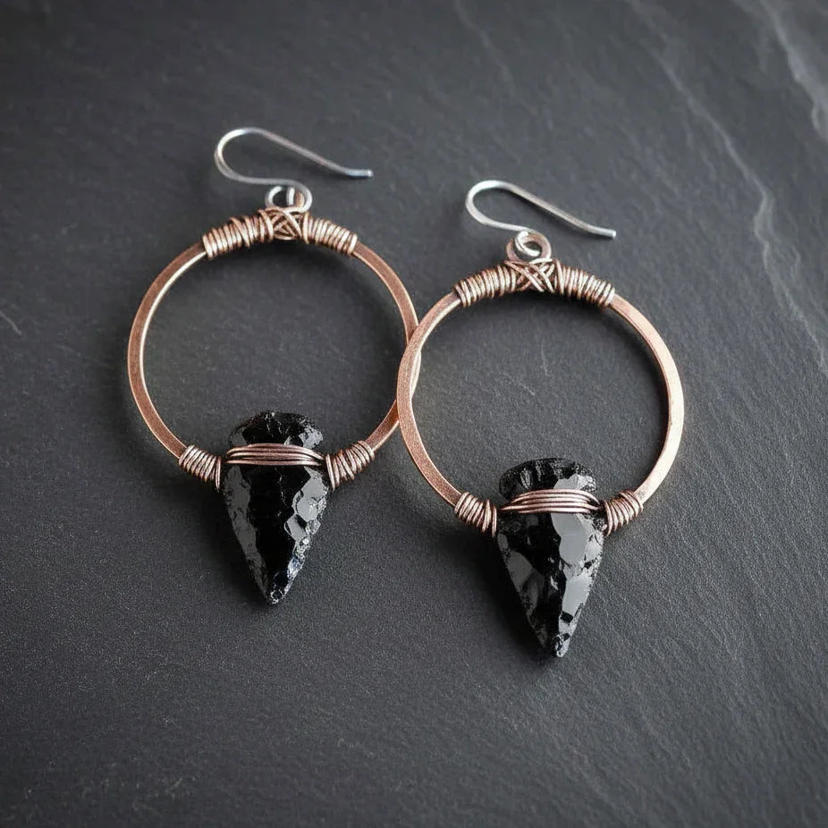 Black obsidian arrowhead earrings on copper hoops - clean product shot