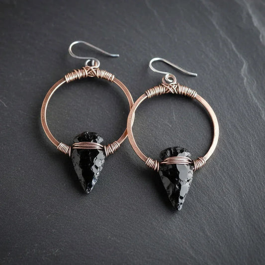 Black obsidian arrowhead earrings on copper hoops - clean product shot